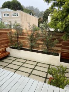 Modern outdoor patio with wooden benches and a minimalist planter.