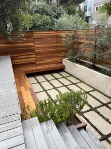 Modern outdoor space with wooden decking and geometric stone patio.